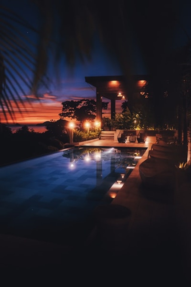 a swimming pool at night with lights on