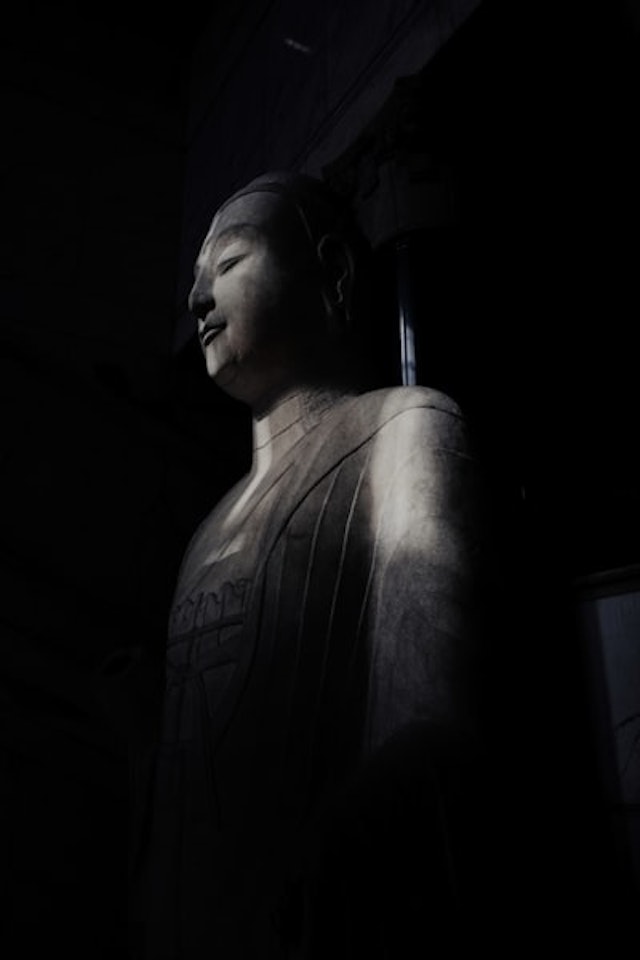 a large statue of a person in a dark room